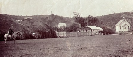 1904 photo with child in foreground on horse in Green St (now Wainui Rd), Union Church to right, original 1883 single classroom school in centre on Stewart St and headmaster's house further up Stewart St hill.